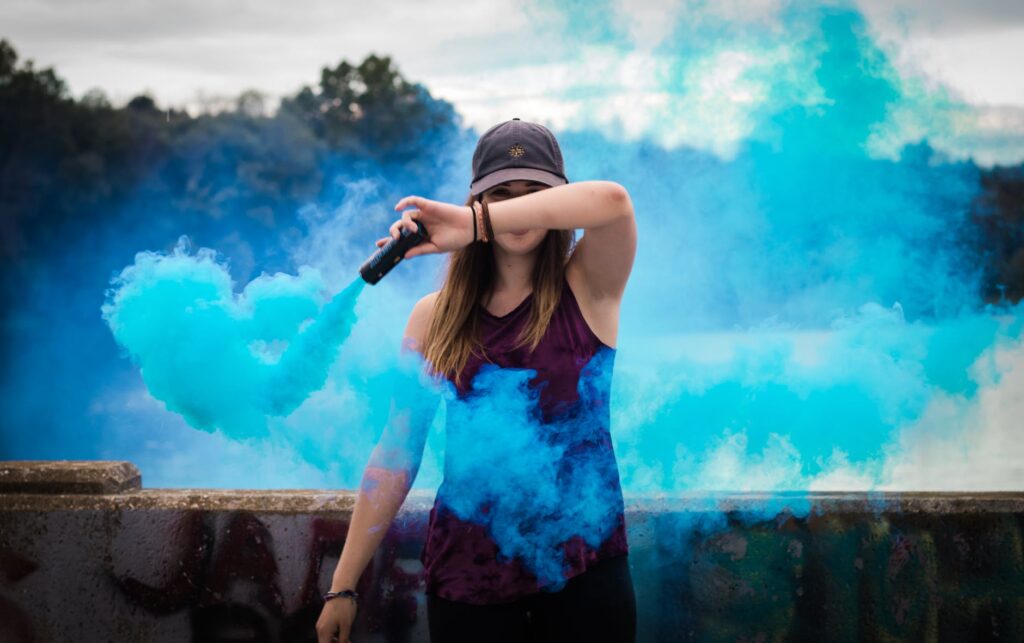 woman holding blue smoke flare