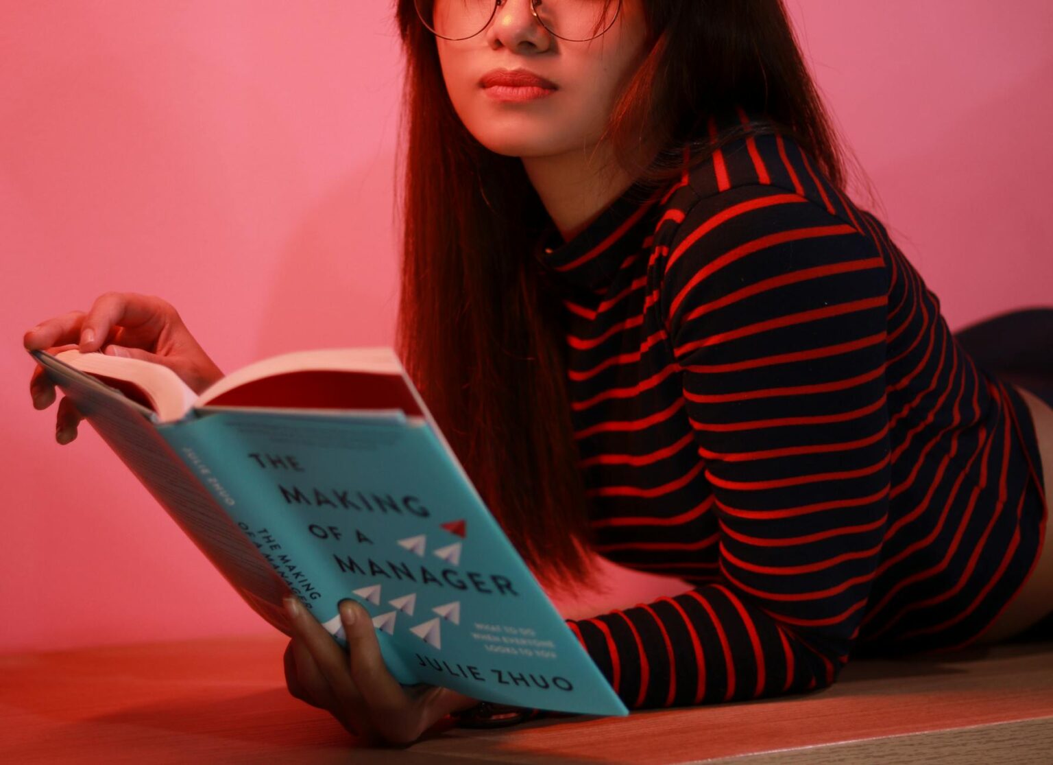 woman in striped long sleeve shirt holding a book