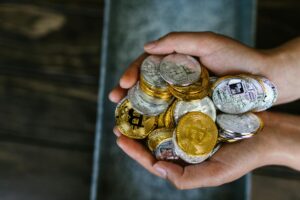 person holding gold and silver coins