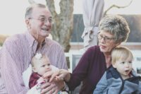 grandmother and grandfather holding child on their lap