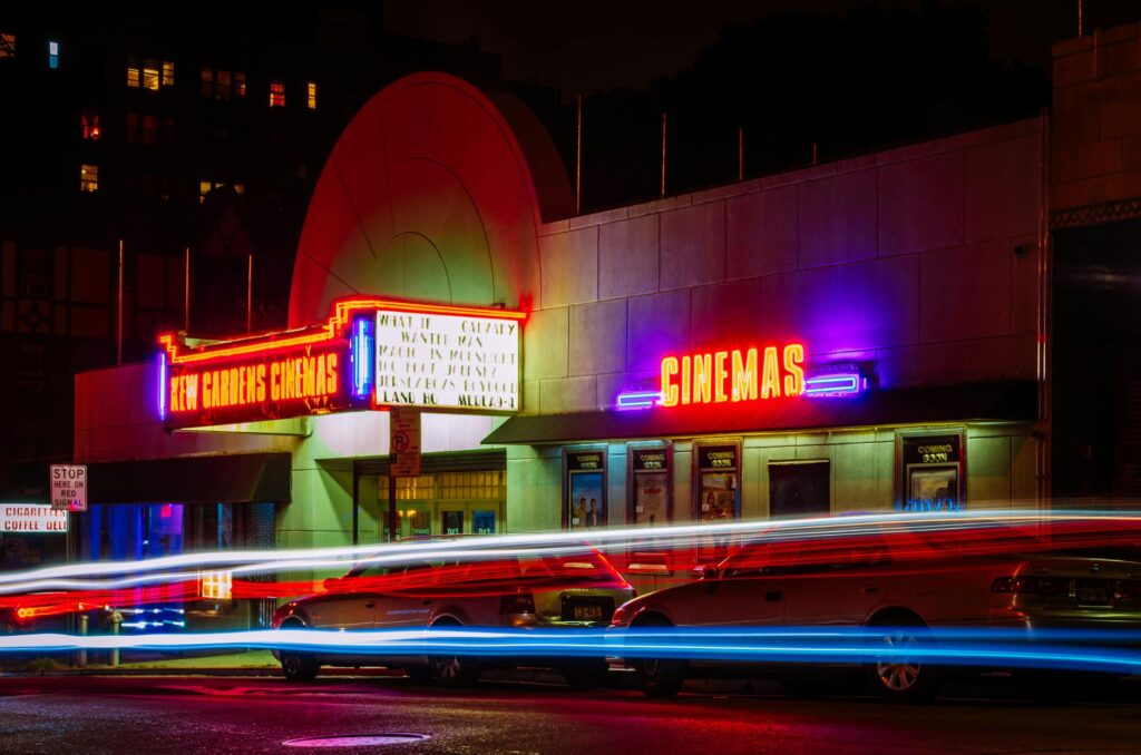 time lapse photography of car lights in front of cinema