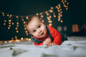 happy little boy crawling on sheet