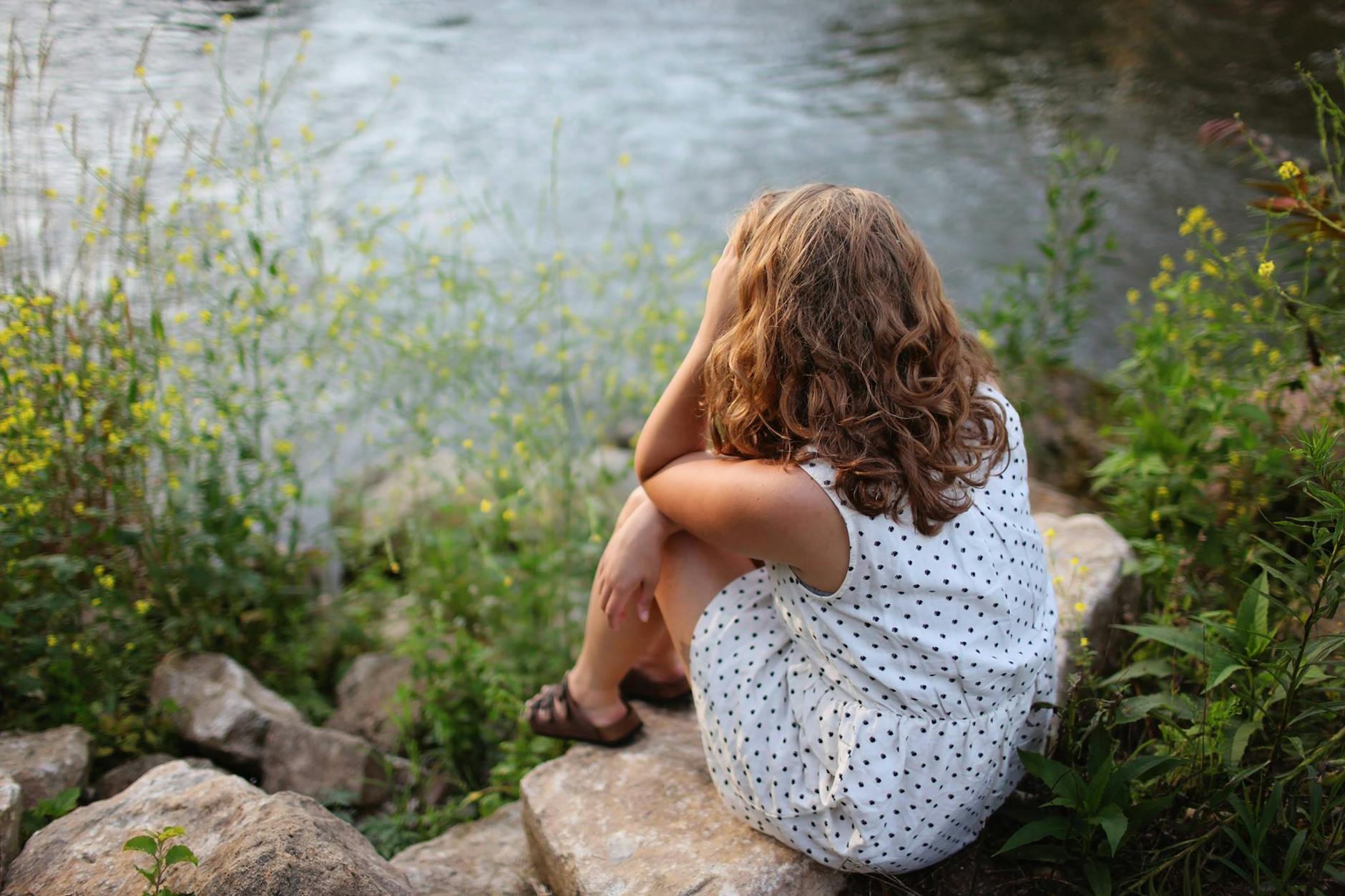 woman sitting by lake