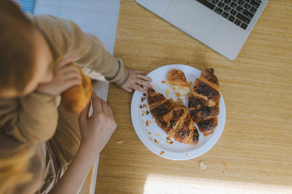 baby s hand on a plate with croissants