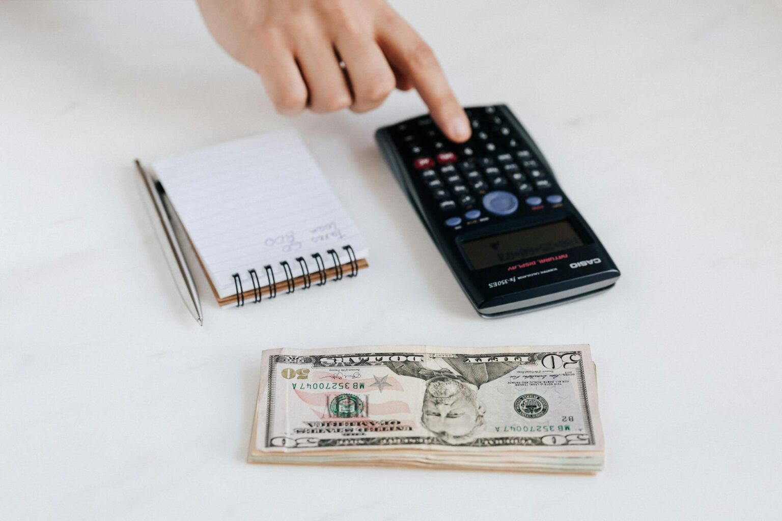 crop unrecognizable accountant using calculator near pile of american dollars