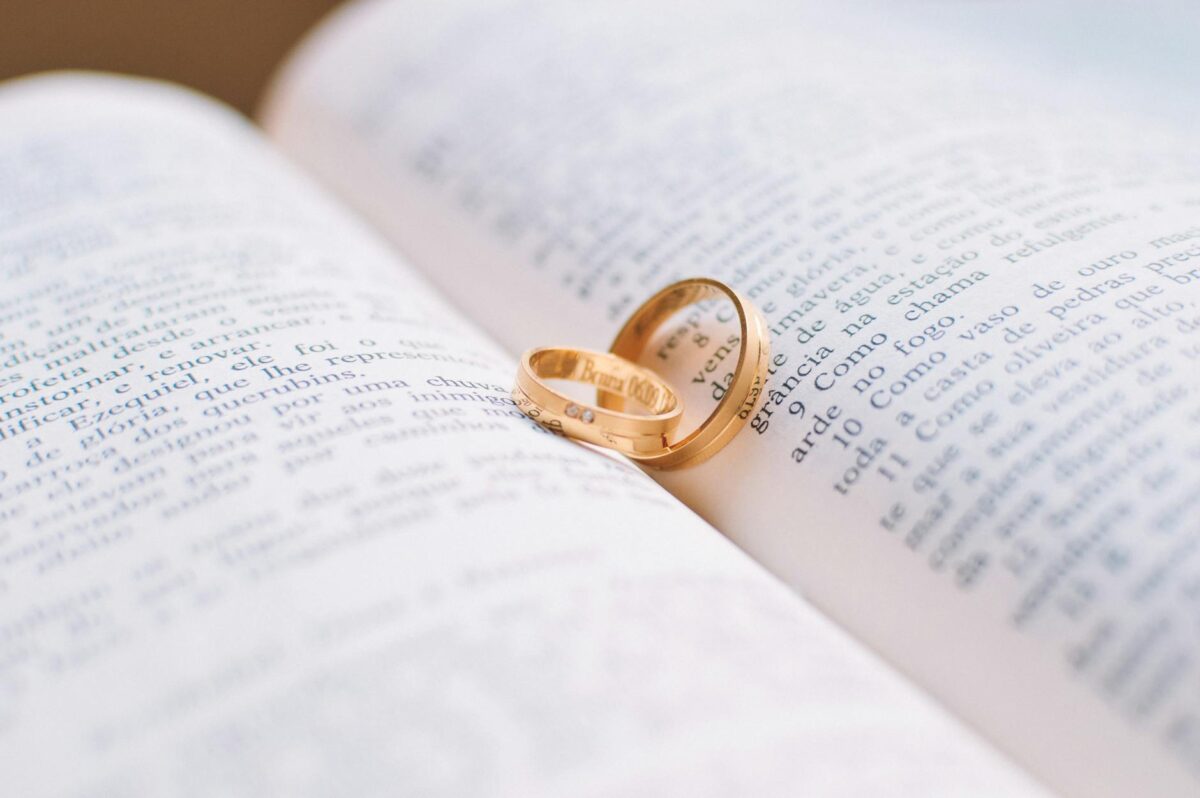 two gold colored wedding bands on book page