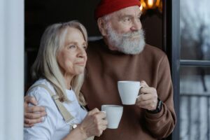 man and woman holding white ceramic mugs