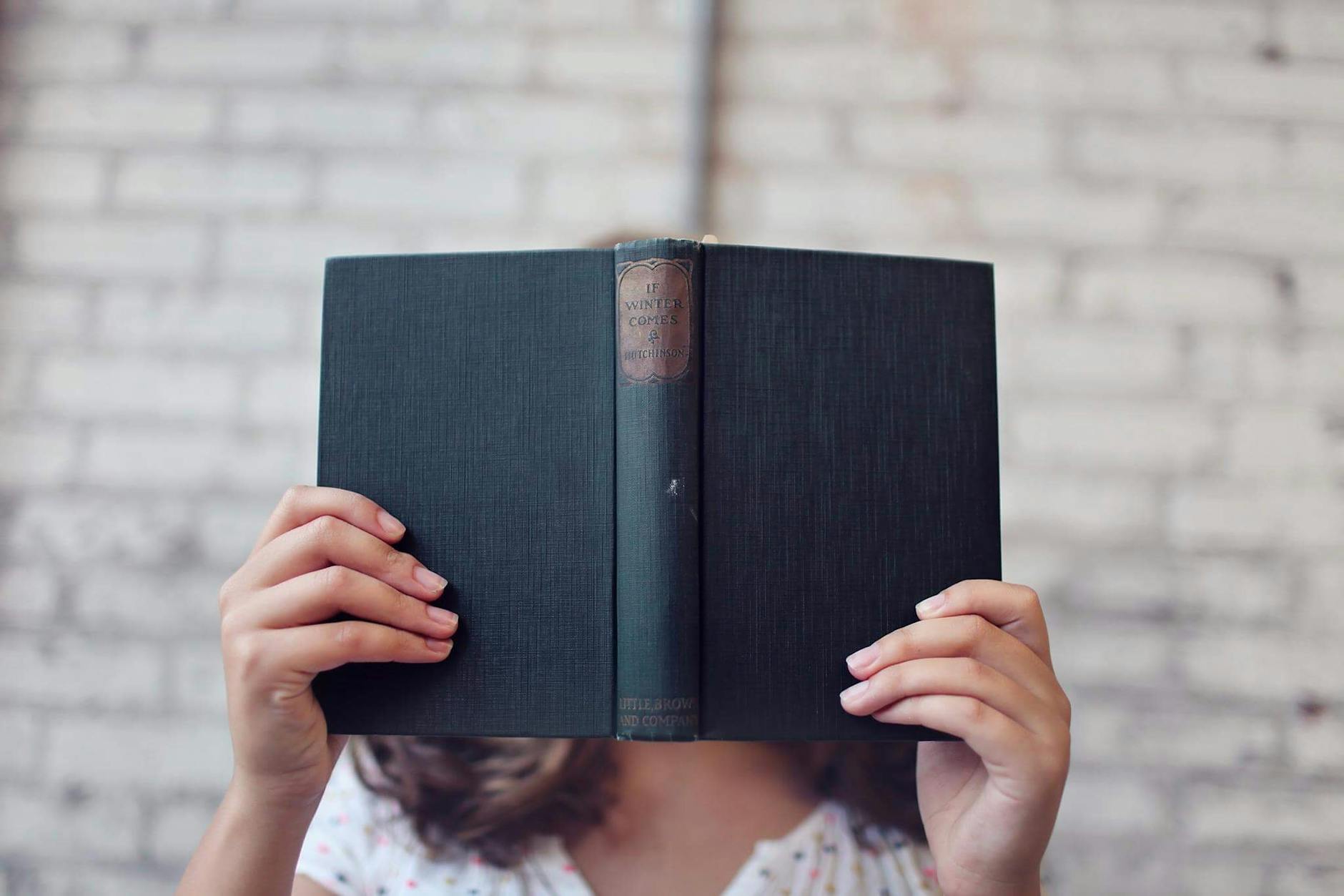 selective focus photography of woman holding book