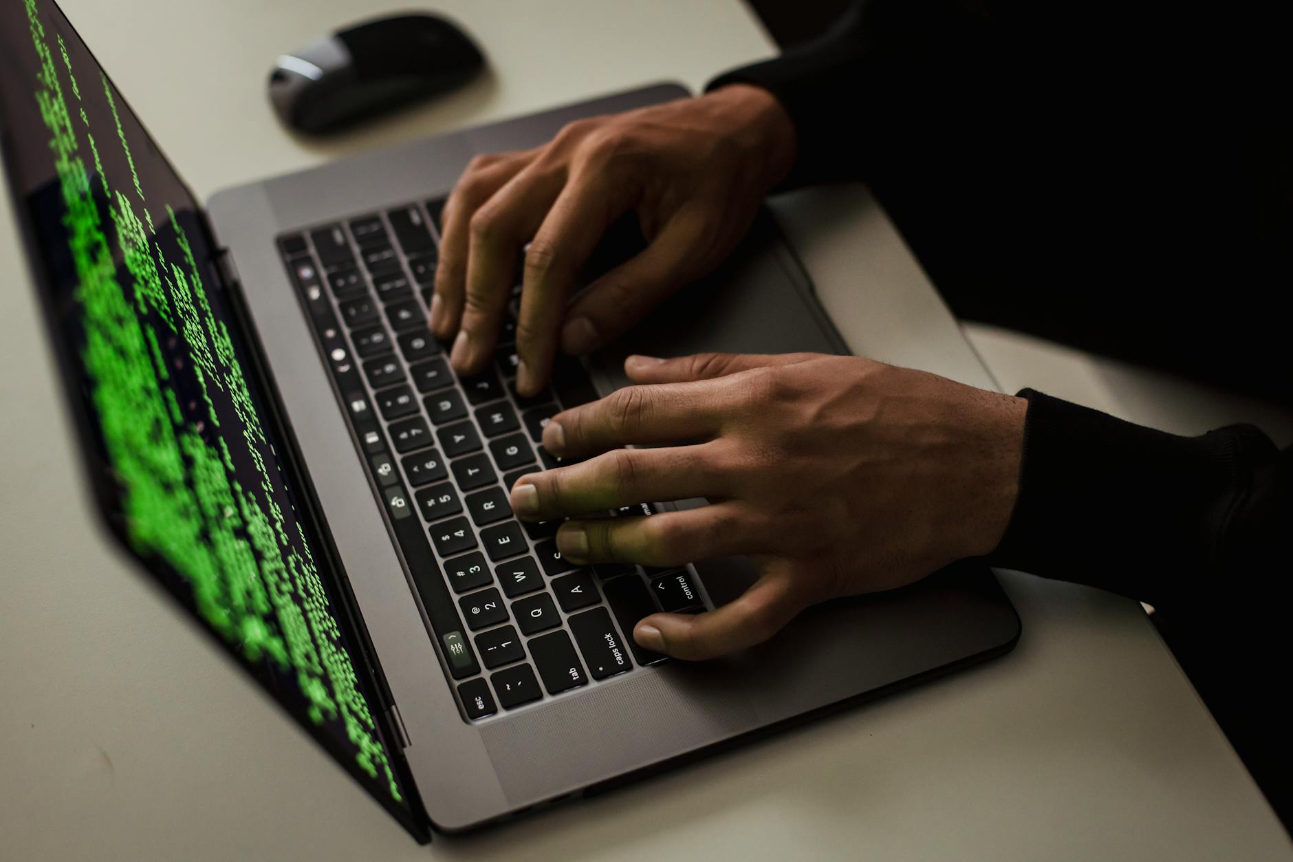 crop cyber spy hacking system while typing on laptop