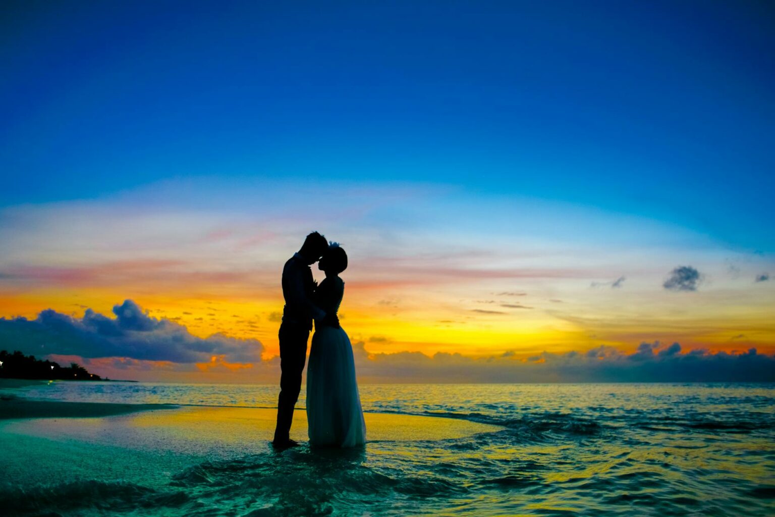 man and woman standing at seashore