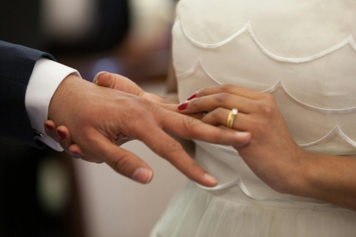 bride putting a ring on grooms hand