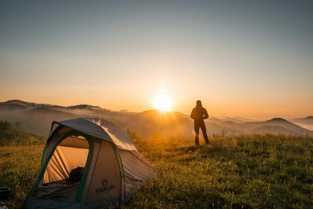 silhouette of person standing near camping tent