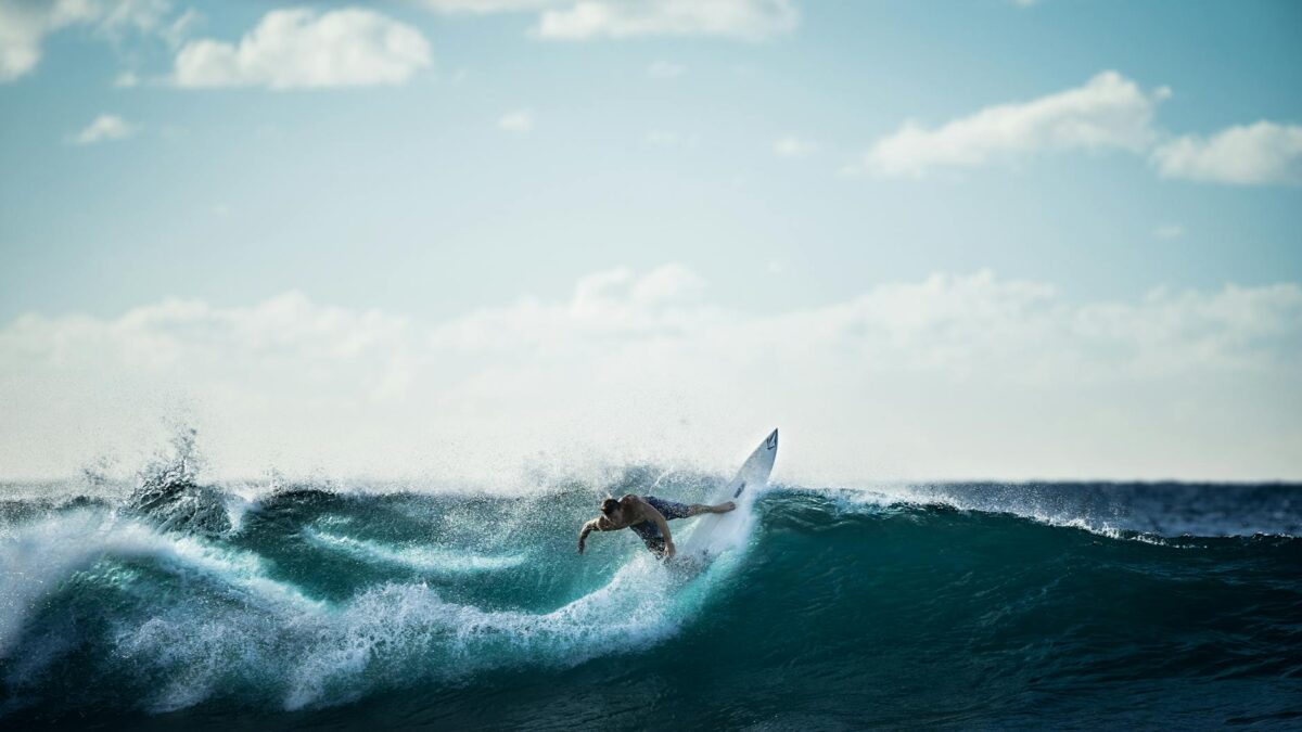 person riding on white surfboard doing surfing